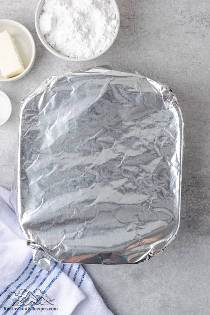 A square baking dish covered with foil