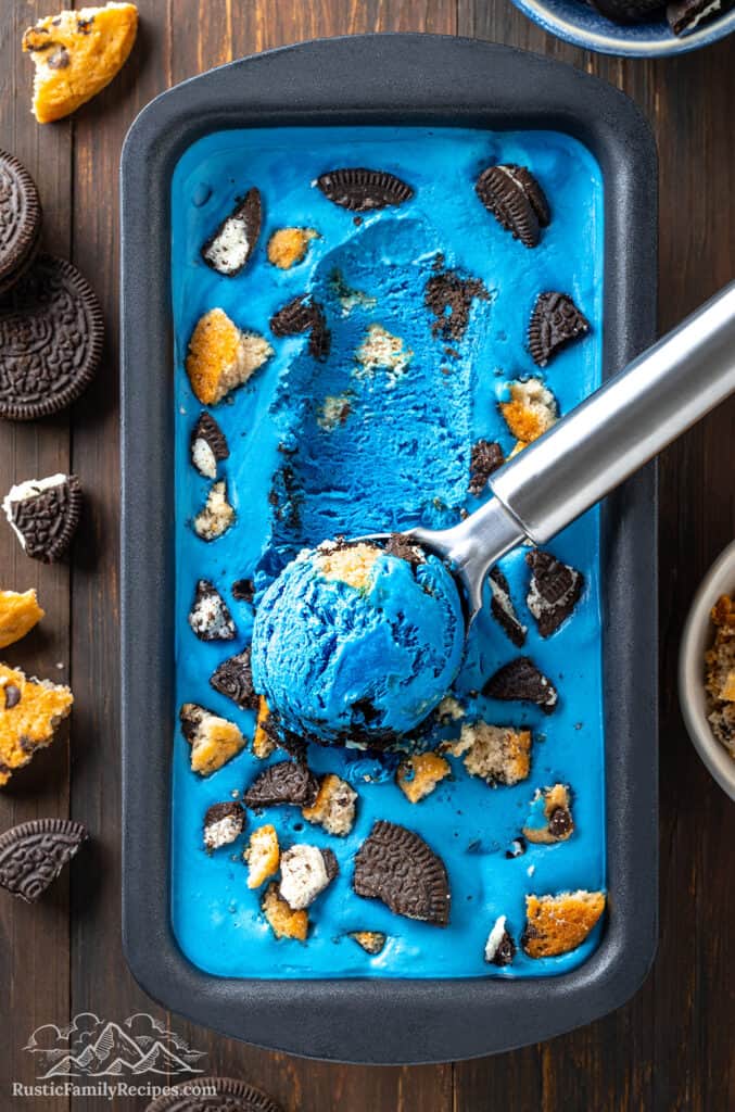 Frozen cookie monster ice cream with an ice cream scooper having shaped a scoop