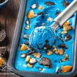 Frozen cookie monster ice cream with an ice cream scooper having shaped a scoop