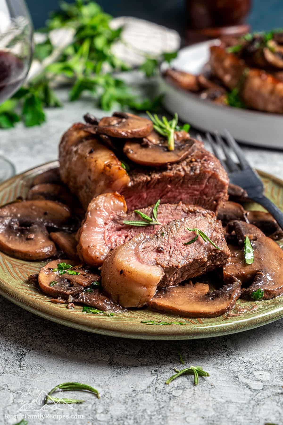 Sliced coulotte steak on a plate topped with buttery mushroom sauce.
