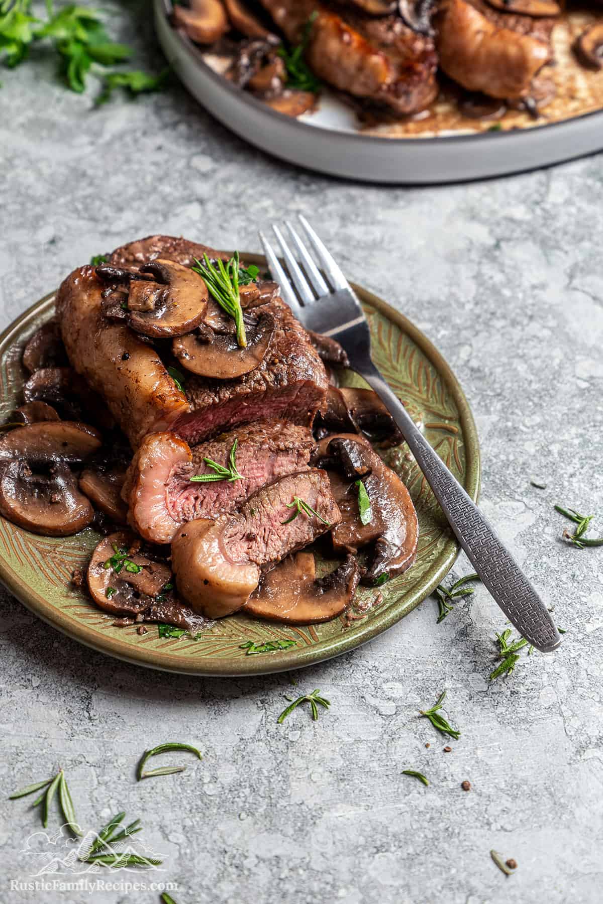 Sliced coulotte steak on a plate topped with buttery mushroom sauce.