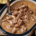 No Peek Beef Tips in a serving dish with a spoon