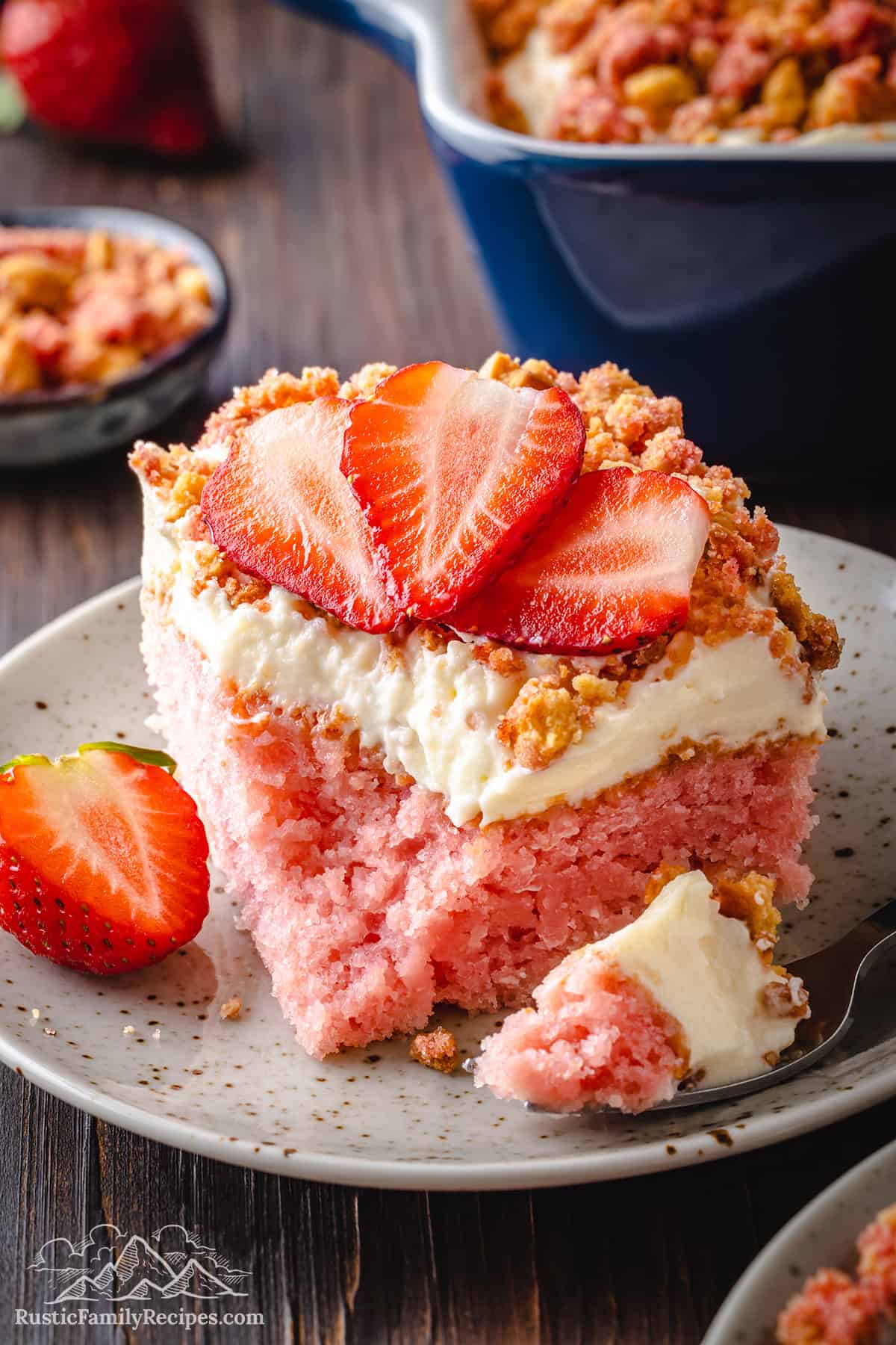 A slice of Strawberry Crunch Cake with a bite taken out.