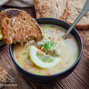A bowl of Avgolemono Soup with two slices of bread