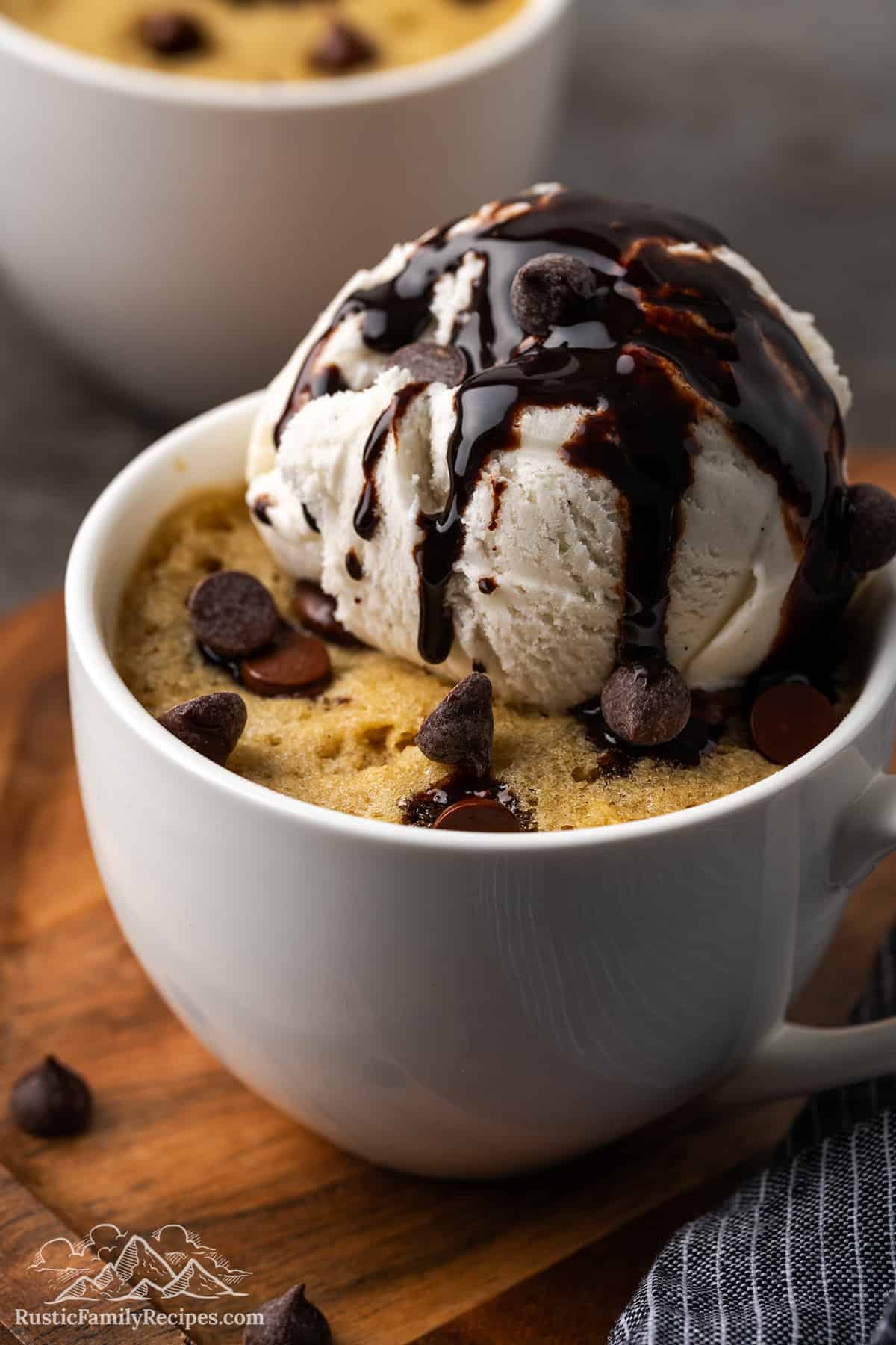 Chocolate Chip Cookie in a Mug served with ice cream and chocolate syrup.