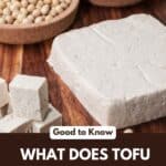 A block of tofu next to soy beans