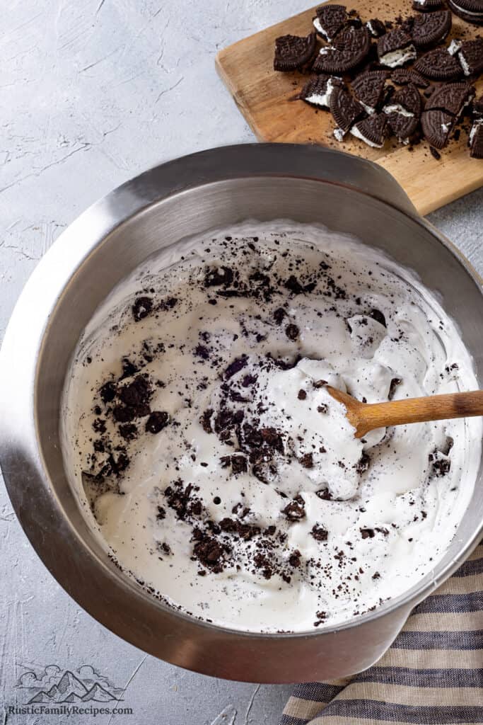No churn ice cream with crushed Oreo cookies in a bowl, ready to freeze