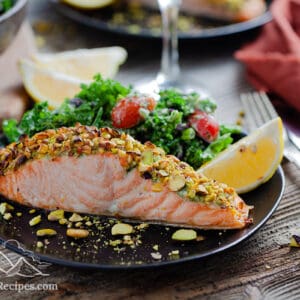 Pistachio Crusted Salmon on a plate with kale salad