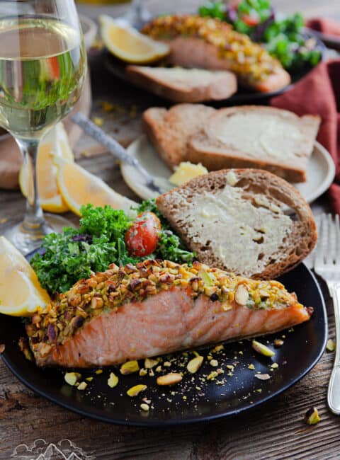 Pistachio crusted salmon on a plate with salad