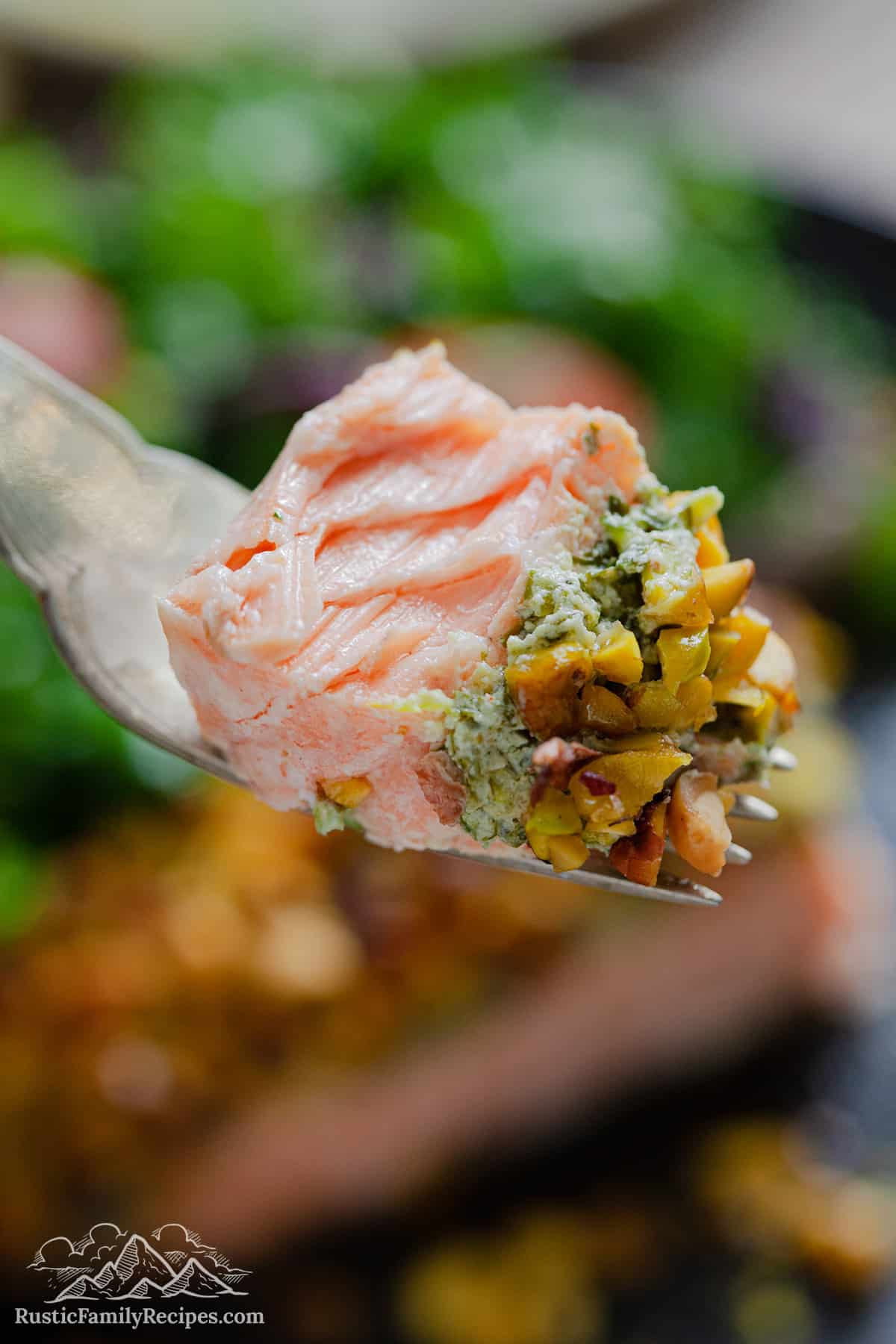 Bite of pistachio crusted salmon on a fork