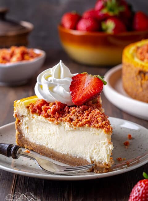 A slice of Strawberry Crunch Cheesecake on a plate