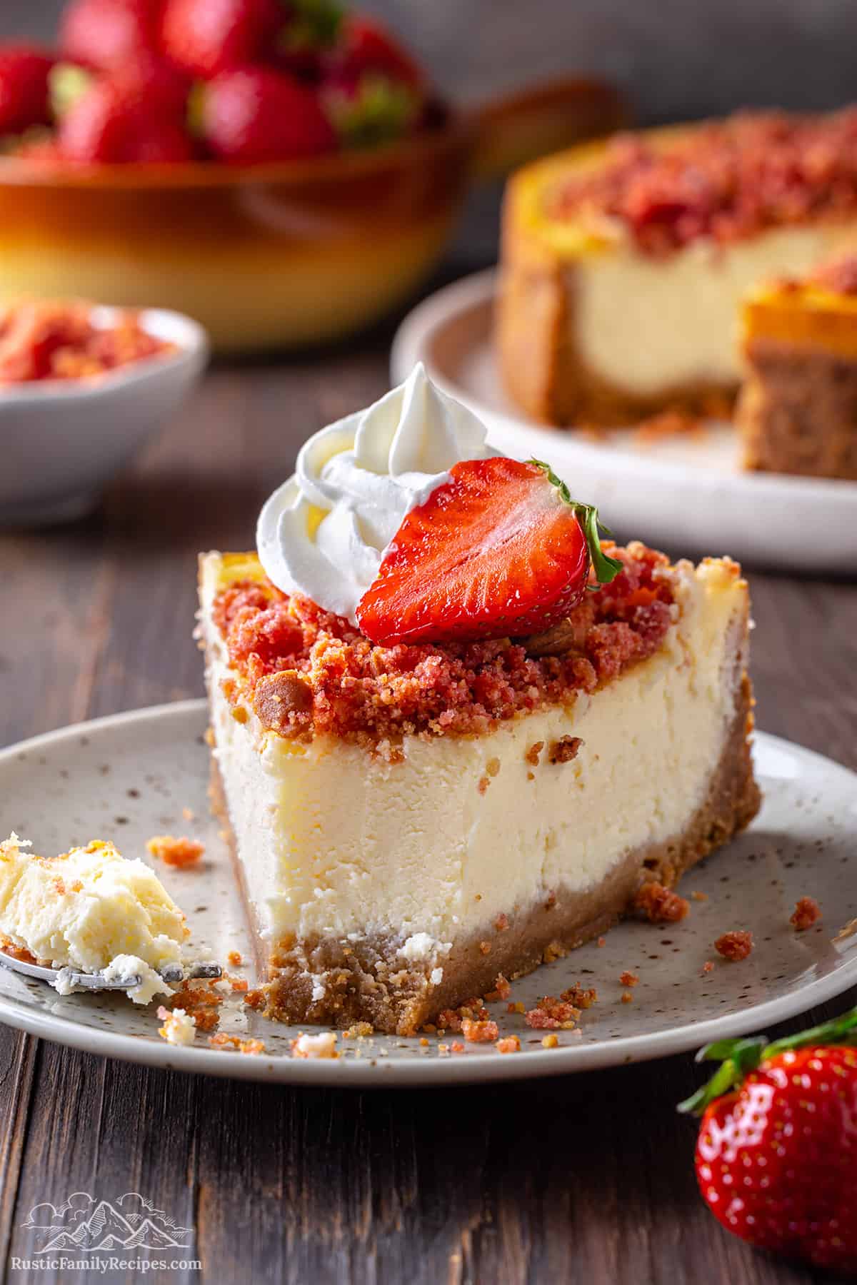Slice of strawberry crunch cheesecake with a bite taken out