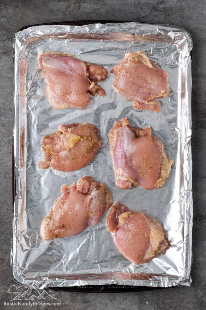 Raw chicken on a baking sheet ready to cook
