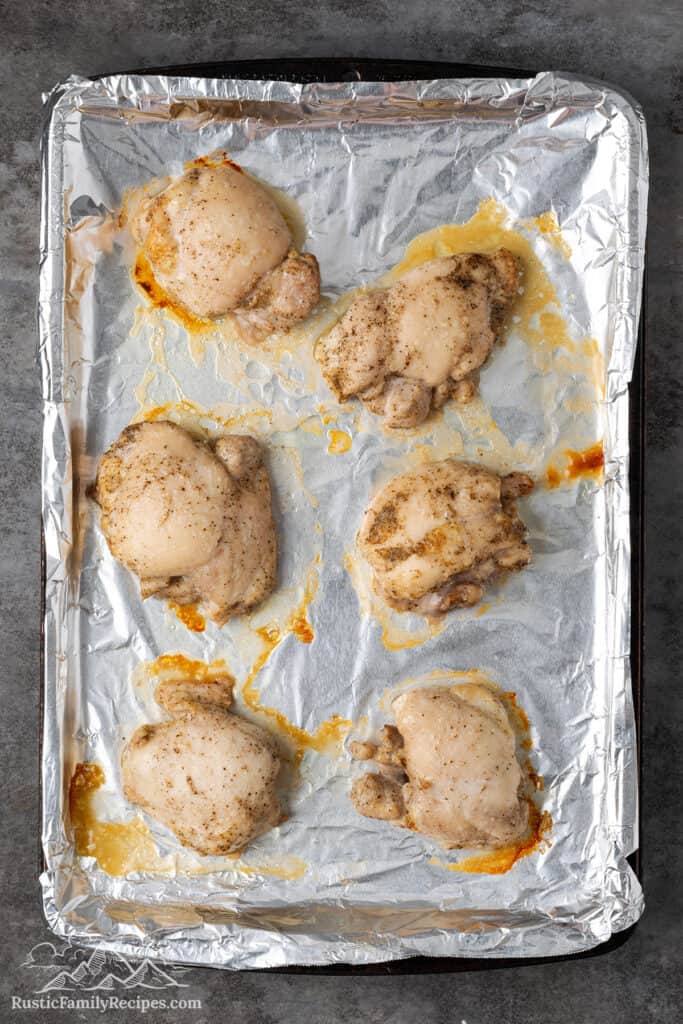 Cooked chicken on a baking sheet lined with foil