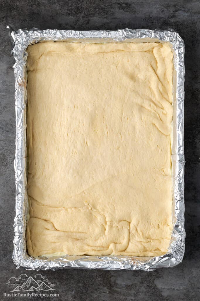 Dough spread on top of the cheesecake filling