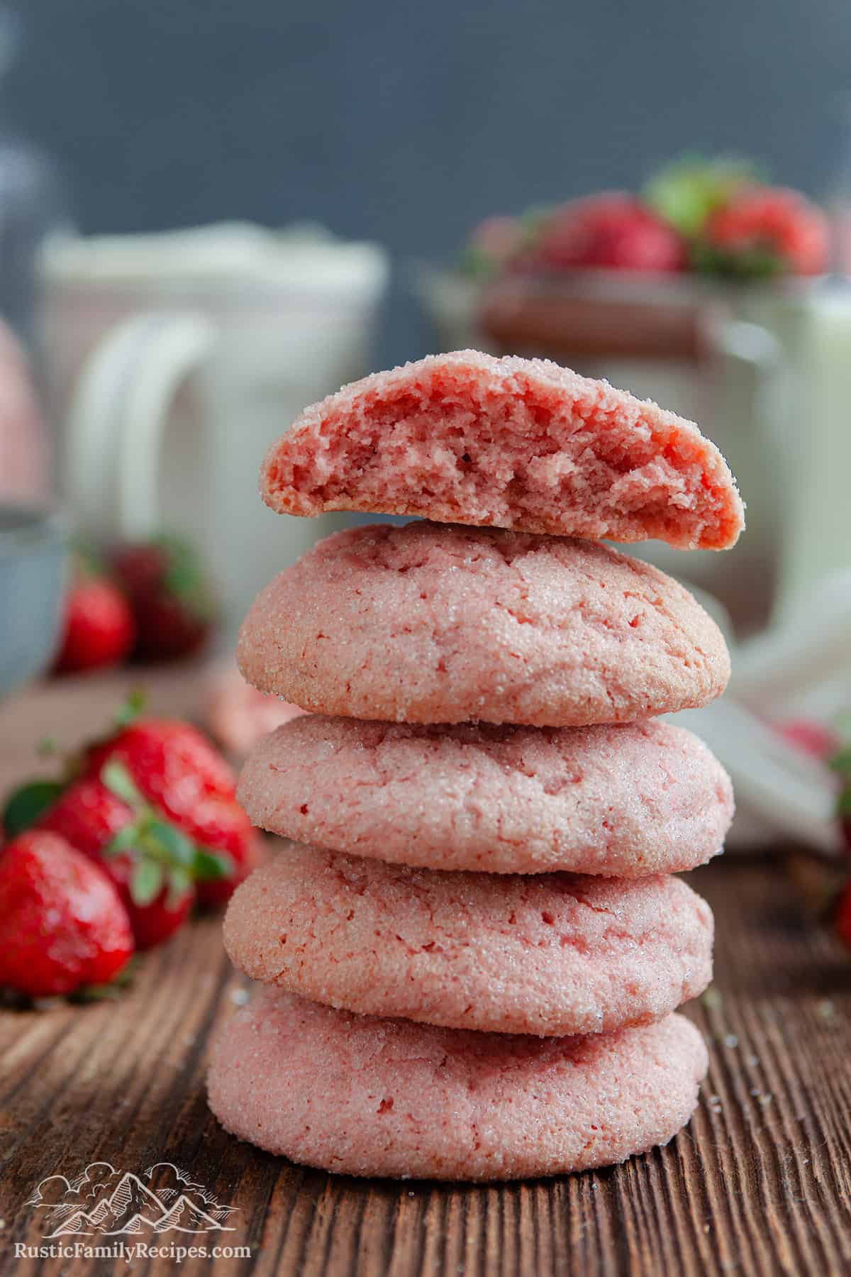A stack of strawberry sugar cookies, one broken in half