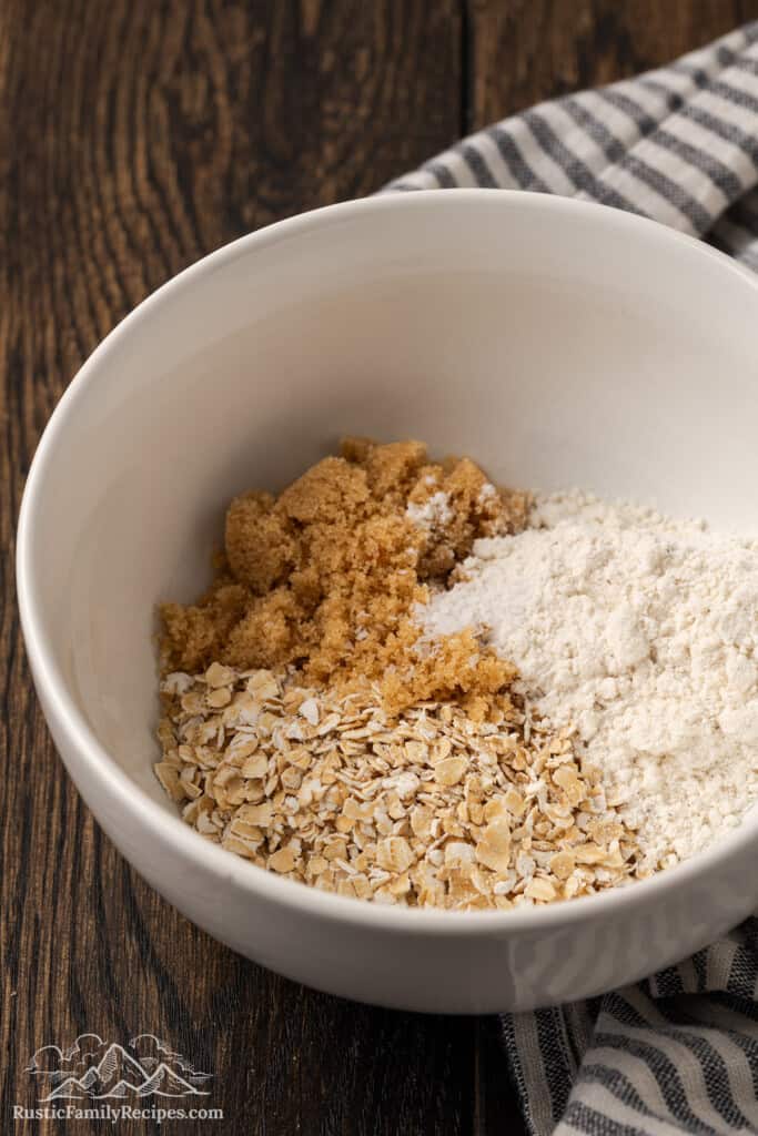 Combining oats, flour and brown sugar in a bowl.