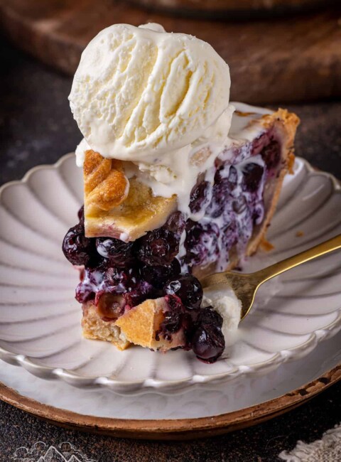 Close up of a slice of blueberry pie with a bite taken out