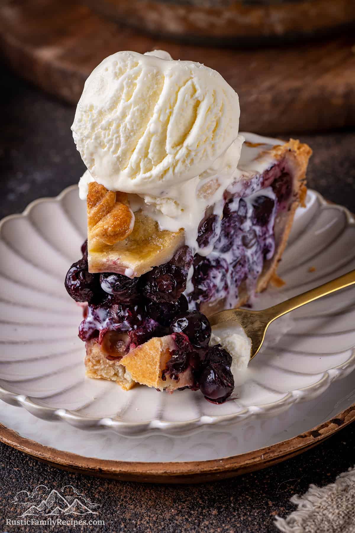 Close up of a slice of blueberry pie with a bite taken out