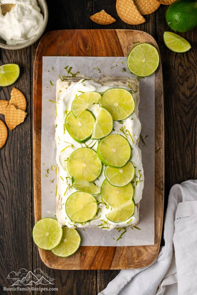 Overhead view of carlota de limon on a cutting board topped with thinly sliced limes.