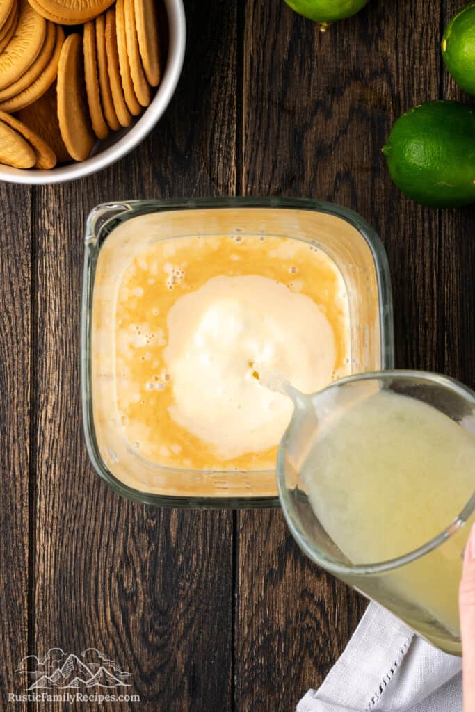 Lime juice poured into a blender with the other cake ingredients.