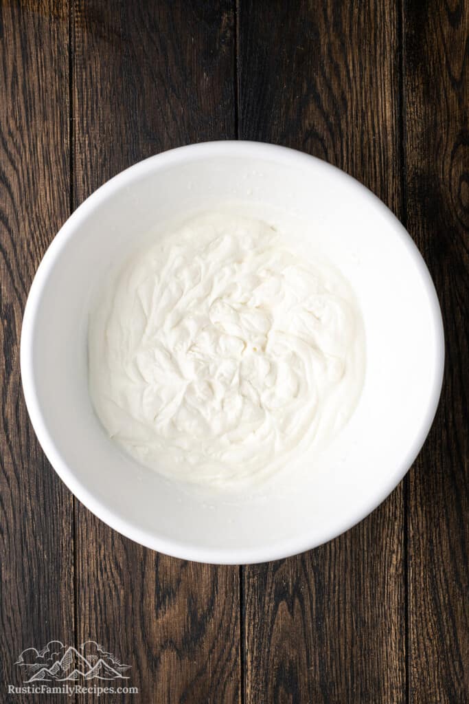 Whipped cream in a white mixing bowl.