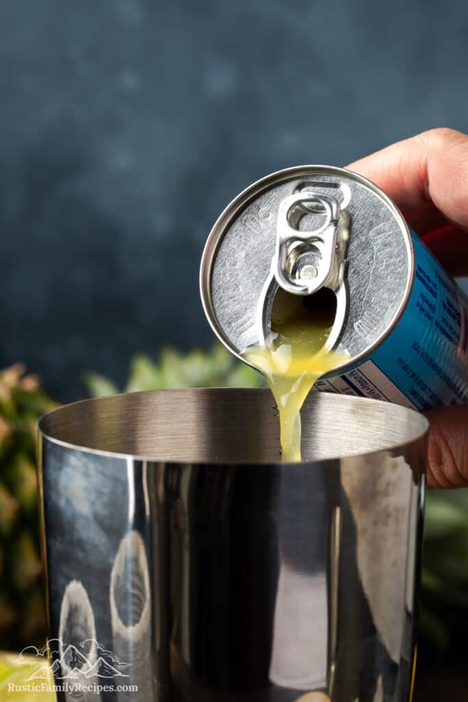 Pouring pineapple juice into a shaker