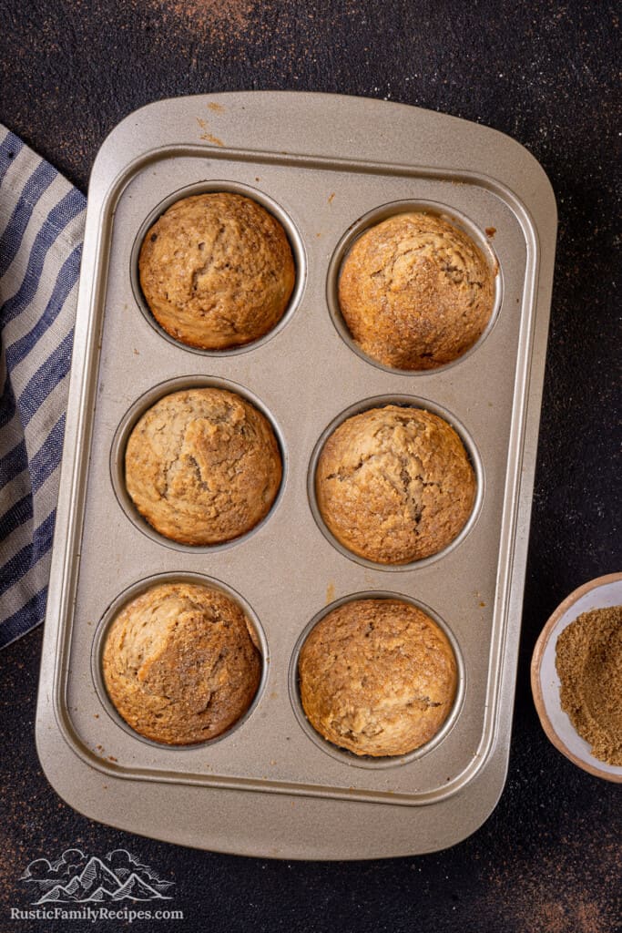 Overhead view of baked banana bread muffins in a muffin tin.