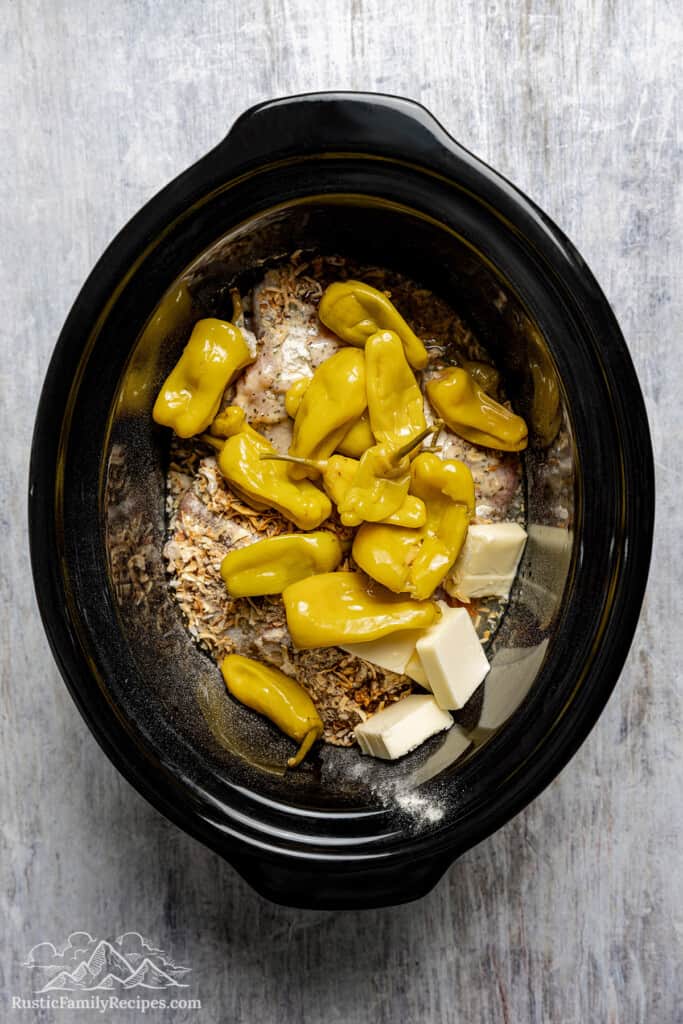 Ingredients for Mississippi Chicken are uncooked in the slow cooker.