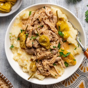 A bowl of Mississippi Chicken served over mashed potatoes.