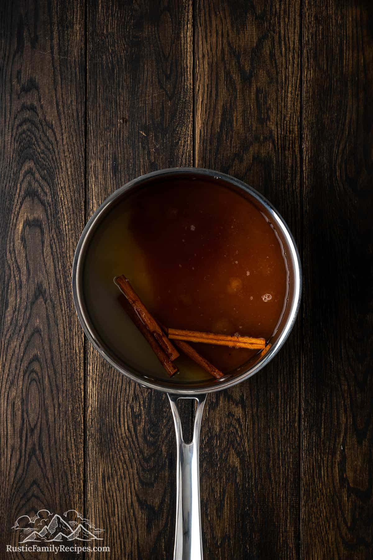 A small pot with cinnamon sticks and simple syrup.