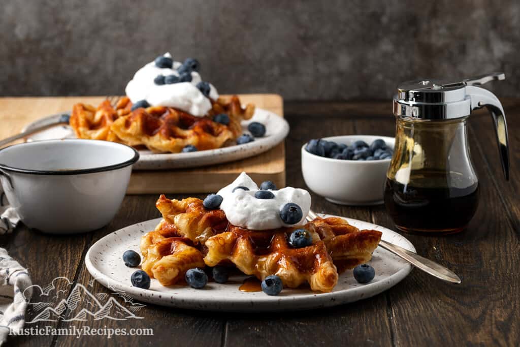 Two plates of croffles with berries and whipped cream