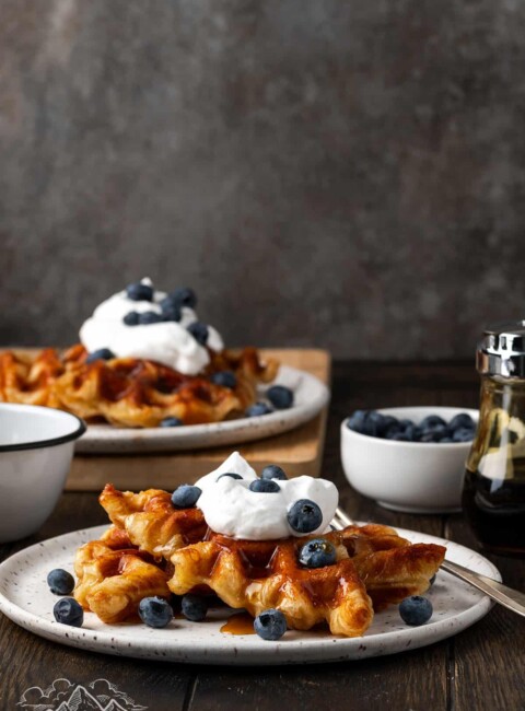 Two plates of croffles with berries and whipped cream