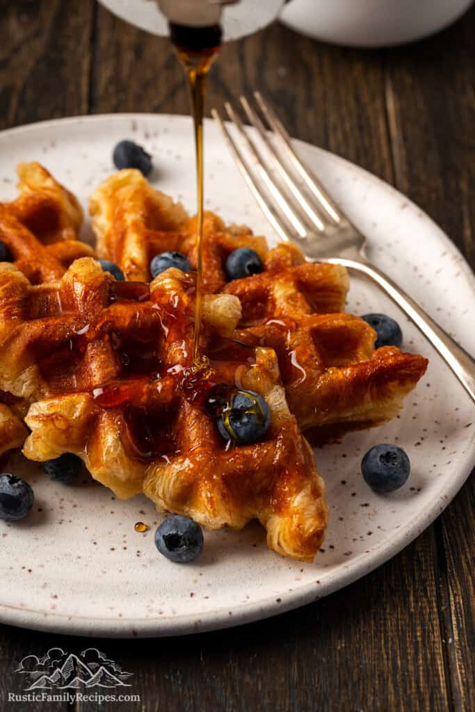 Pouring maple syrup on cooked croffles