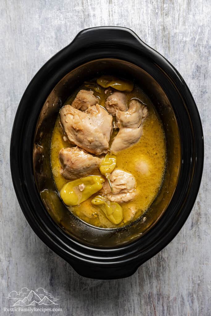 Ingredients for Mississippi Chicken are cooked in the slow cooker.