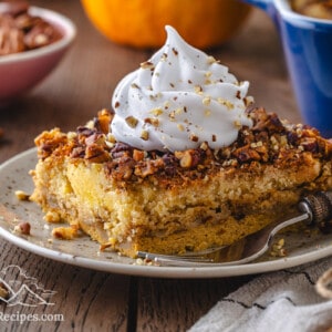 Slice of pumpkin crunch cake with whipped cream and a fork