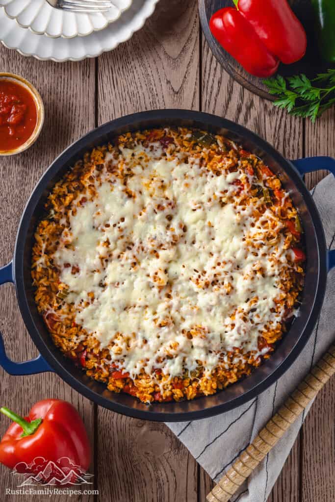 Stuffed pepper casserole in a Dutch oven topped with melted cheese.
