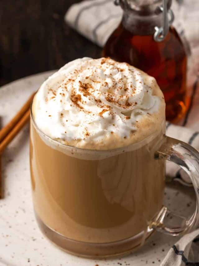 Side view of a cinnamon dolce latte on a white plate.