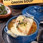 A blue soup bowl with french onion soup.